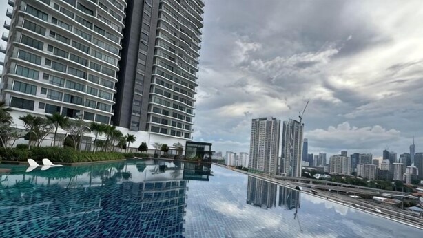 A modern hotel with a rooftop infinity pool, high-rise buildings, and a cloudy sky. - Datum Jelatek Superb Suite KL By LH (Ampang)