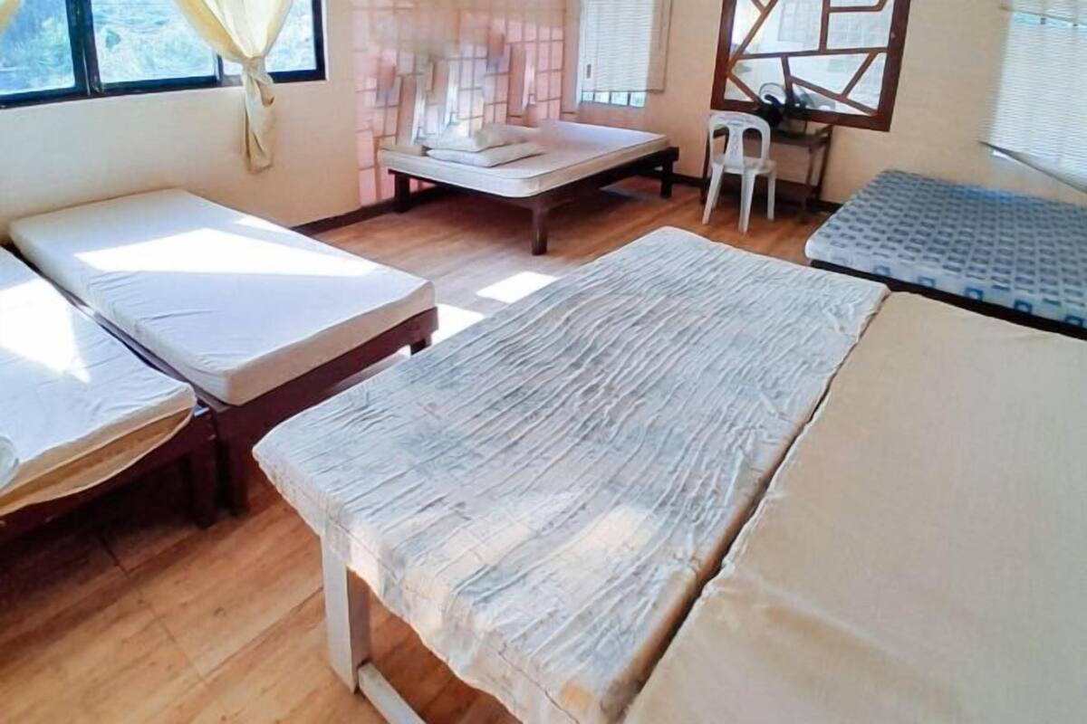 A room with two beds, a desk, and a chair.