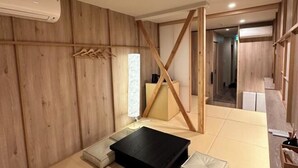A room with wooden panel walls, a black table, a white sofa, and a wooden partition. - WATEL ASAKUSA (Tokyo)