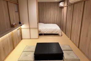 A compact room with a bed, a black table, and a wooden floor. - WATEL ASAKUSA (Tokyo)