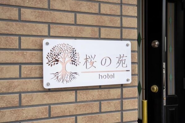 A hotel sign with a tree logo and Japanese text.