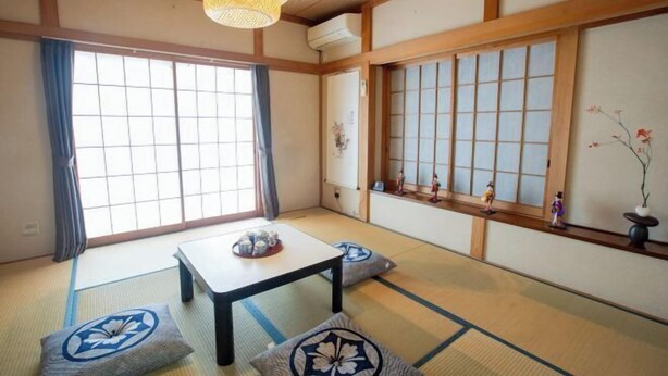 A traditional Japanese room with tatami flooring, a low table, and sliding doors. - Sakura Retreat (Tokyo)