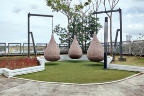 Un terrain de jeux avec des balançoires et des structures sphériques suspendues.
