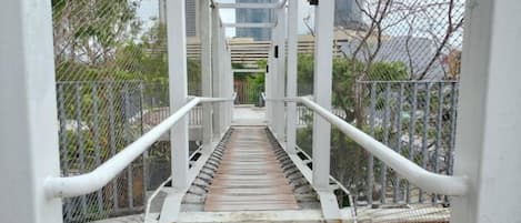 A pedestrian bridge with railings and a wooden walkway.