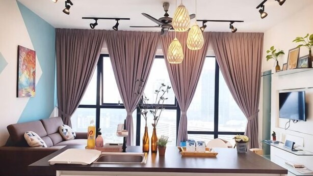 A modern living room with a sofa, a dining area, a kitchen island, and large windows with curtains. - Delight Homestay Mosaic Southkey (Plentong)