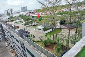 A high-rise building with a rooftop garden and a parking area. - Delight Homestay Mosaic Southkey (Plentong)