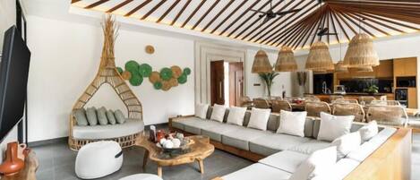 A modern living room with a sofa set, a coffee table, and a hanging chair.