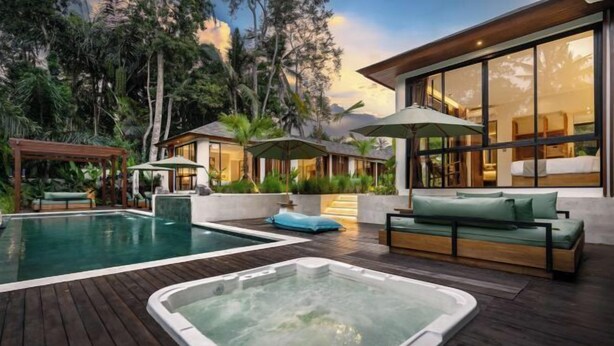 A modern outdoor pool area with hot tubs, wooden decking, and lush tropical vegetation. - Villa Dream Life by BaliSuperHost (Bali)