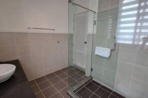 A bathroom with a glass shower enclosure, a white sink, and a towel hanging on the door. - Villa pool access @ Boathouse Hua Hin (Cha-am)