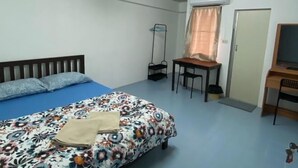A bedroom with a bed, a desk, a chair, and a television. - Rattanakorn Mansion (Bangkok)