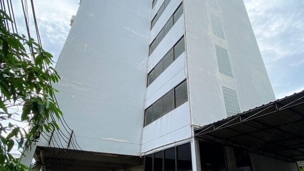 A tall, modern building with a white facade and multiple windows. - Rattanakorn Mansion (Bangkok)