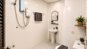 A modern bathroom with a shower, sink, toilet, and a mirror. - Room-charming Guest Room in Central Pa T (Patong)