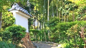 A traditional Japanese-style building with a tiled roof and a stone pathway leading to it. - Iidaya Hotel (Yokohama)