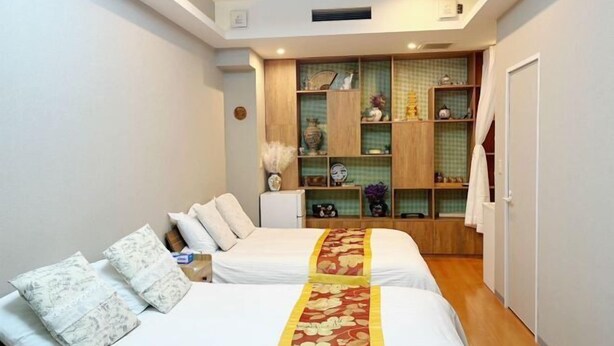 A bedroom with two beds, a built-in wardrobe, and a small table. - MIIYAVI Hotel (Tokyo)
