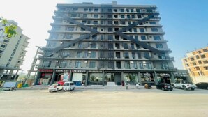 A multi-story building with a modern architectural design, featuring a central staircase and multiple balconies. - Cozy Apartment in Bahria Town. (Rawalpindi)
