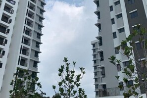 A view of high-rise residential buildings with balconies, a clear sky, and some greenery in the foreground. - Pool View Air-Con Studio @Tiara Imperio Bangi (Kajang)