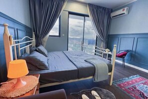 A hotel room with a bed, a nightstand, a lamp, a chair, and a view of the city. - Pool View Air-Con Studio @Tiara Imperio Bangi (Kajang)