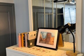 A desk with a framed picture, a lamp, and books. - Pool View Air-Con Studio @Tiara Imperio Bangi (Kajang)