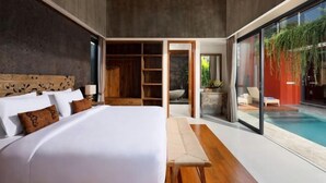 A modern bedroom with a large bed, wooden headboard, and a view of a swimming pool. - VILLA ELIZA CANGGU (Bali)