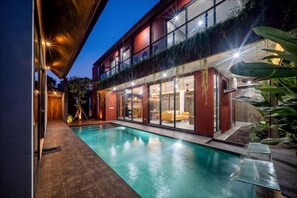 A modern house with a swimming pool, large windows, and a covered outdoor area. - VILLA ELIZA CANGGU (Bali)