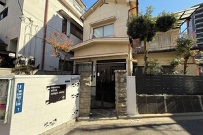A residential building with a gated entrance, a visible mailbox, and a small tree in front. - Nestay villa Tokyo Ueno (Tokyo)