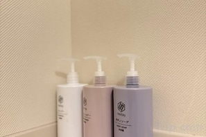 Three bottles of body wash against a textured wall. - Nestay villa Tokyo Ueno (Tokyo)