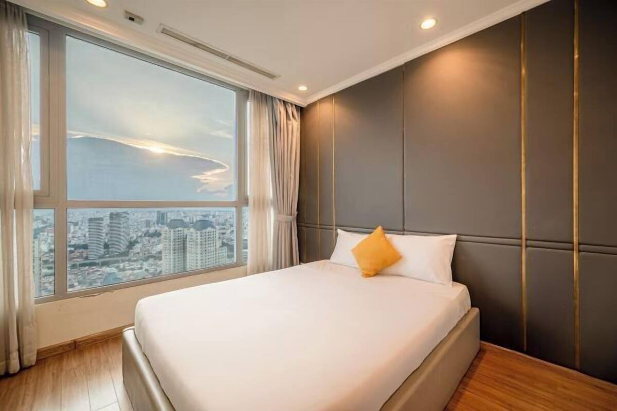 Ein Hotelzimmer mit großem Fenster, einem Bett und Blick auf die Stadt.