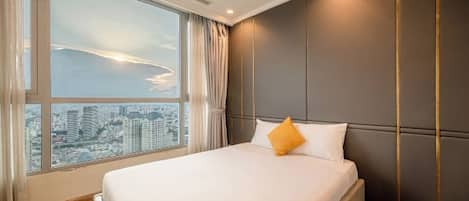 Una habitación de hotel con un ventanal grande, una cama y vistas a la ciudad.