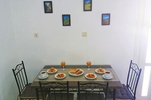 A dining table with plates, glasses, and chairs. - Akakia Residence (Naxos)