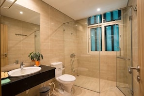 Une salle de bain moderne avec une douche à parois de verre, des toilettes et un lavabo avec un miroir.