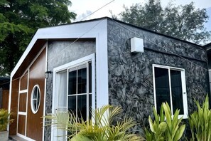 A modern building with a stone facade, large windows, and a wooden door. - Cina Home (Chiang Mai)
