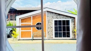 A modern house with a garage, a stone facade, and a wooden door. - Cina Home (Chiang Mai)