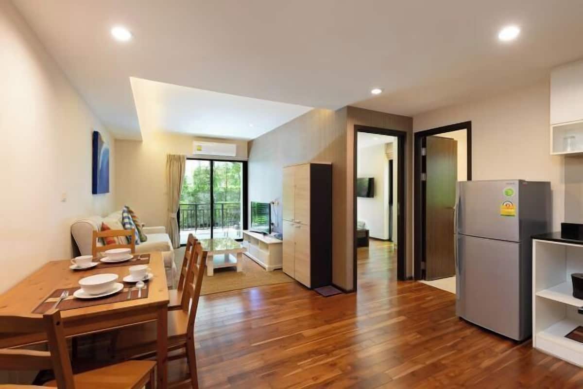A modern apartment with a dining area, kitchen, and a balcony with a view.