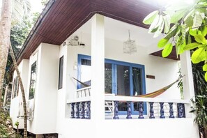 A two-story building with a balcony, a hammock, and a hanging light fixture.