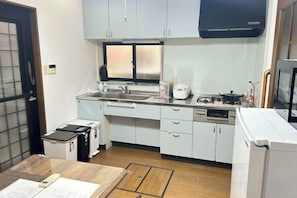 A compact kitchen with a microwave, stove, and sink. - HAMANOCHO BEEKAN (Takamatsu)