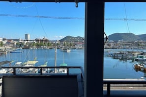 A view from inside a building looking out at a marina with boats, a bridge, and a mountain in the background. - HAMANOCHO BEEKAN (Takamatsu)