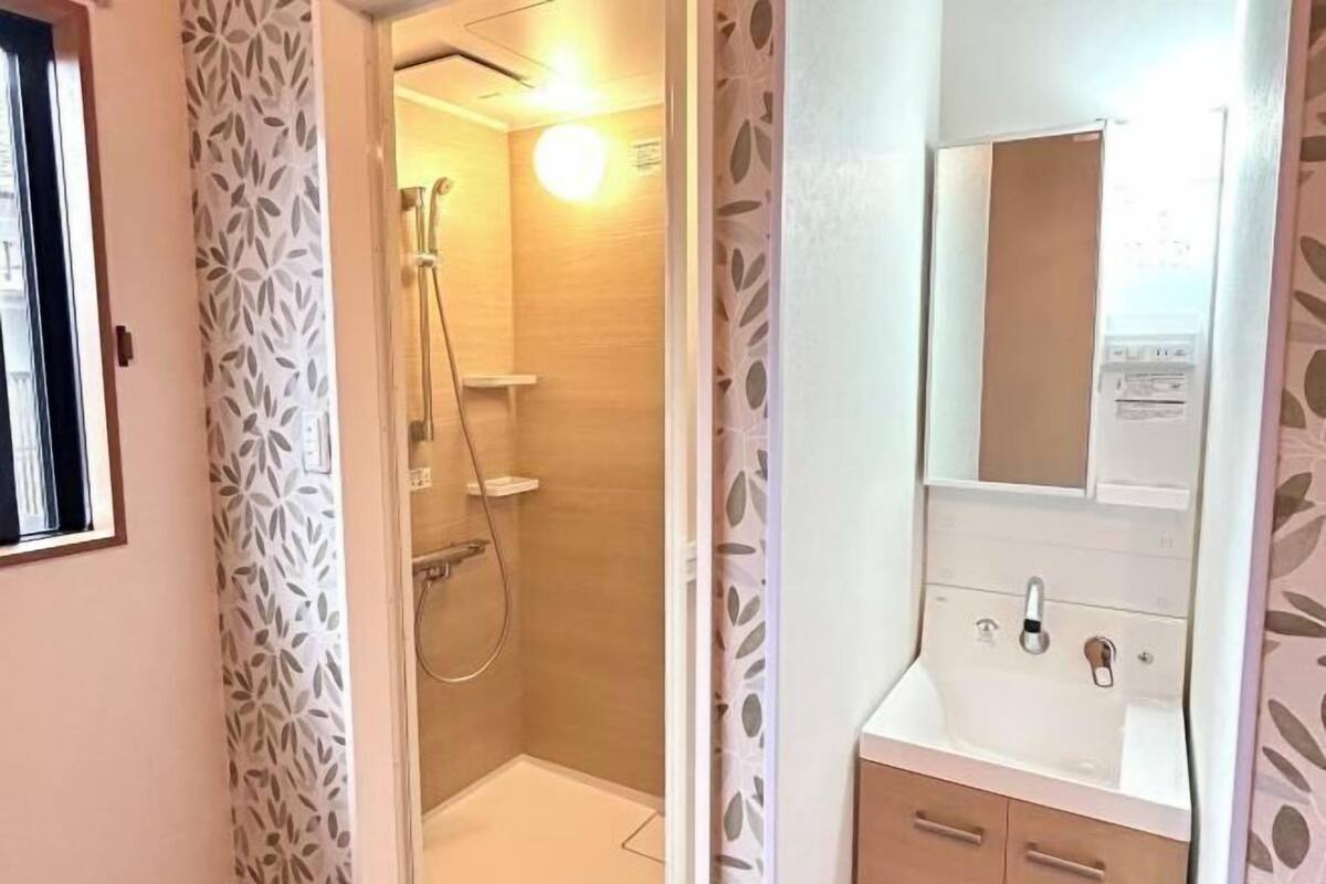 Un baño con ducha, lavabo y espejo.