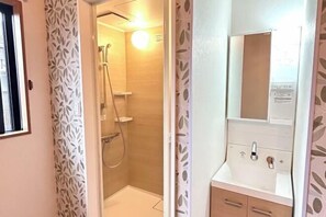 A bathroom with a shower, a sink, and a mirror. - HAMANOCHO BEEKAN (Takamatsu)