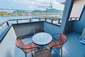 A balcony with a table and chairs, overlooking a marina and cityscape. - HAMANOCHO BEEKAN (Takamatsu)