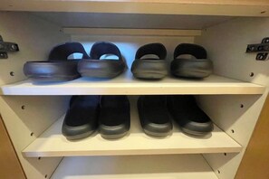 A shoe rack with multiple shelves holding pairs of shoes.