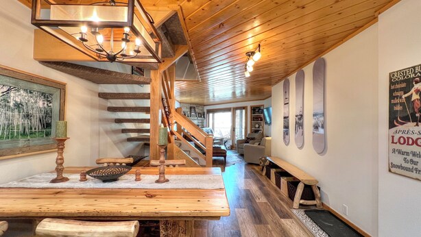 Interior de madera con una escalera, muebles de madera y un letrero en la pared.