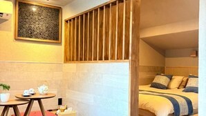 A bedroom with a bed, a small table with a teapot, a potted plant, and a wooden slat partition. - SOSEI-IN@YASAKA TEMPLE (Kyoto)