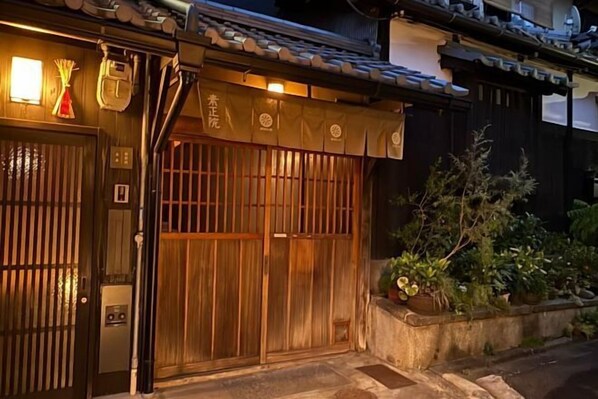 Il s’agit d’un bâtiment traditionnel japonais, doté d’une porte en bois, d’une petite entrée et d’un toit recouvert de tuiles.