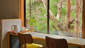 A room with a window overlooking a forest, a desk with a chair, and a pitcher on the windowsill. - SOSEI-IN@YASAKA TEMPLE (Kyoto)