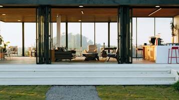 A modern outdoor seating area with a mix of chairs and sofas, a small table, and a grill.