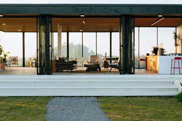 A modern outdoor seating area with a mix of chairs and sofas, a small table, and a grill.