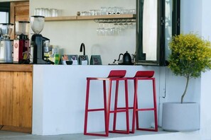 A bar area with stools, a coffee machine, and a potted plant. - Akano Doichang (Mae Suai)