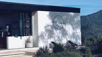 Un edificio moderno con un diseño circular prominente en la fachada, una entrada visible y escalones que conducen a la puerta.