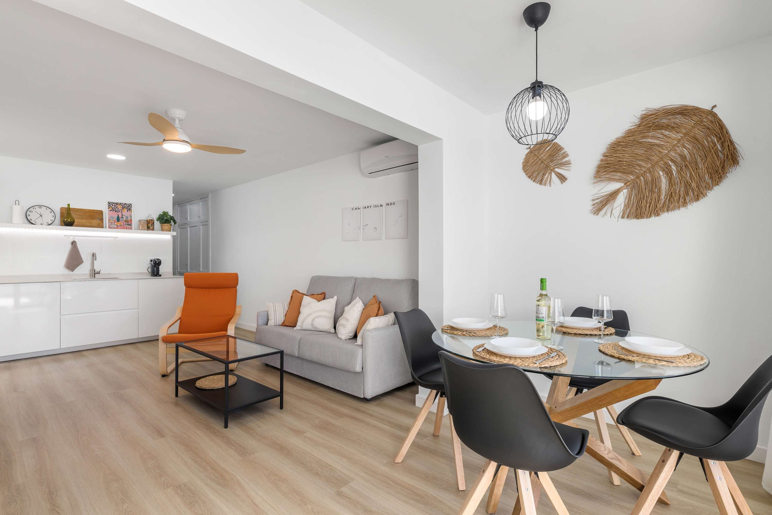 Un espacio habitable moderno con comedor, sofá y una mesa de centro.