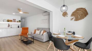 Un espacio habitable moderno con comedor, sofá y una mesa de centro.